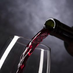Rotwein wird in ein Glas eingeschenkt