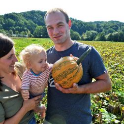 Familie mit Kleinkind am Kürbisacker