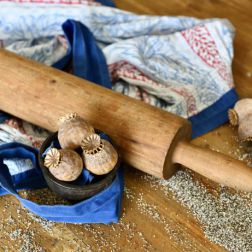 Grau- und Weißmohn mit einem Nudelholz und einer Dirndlschürze