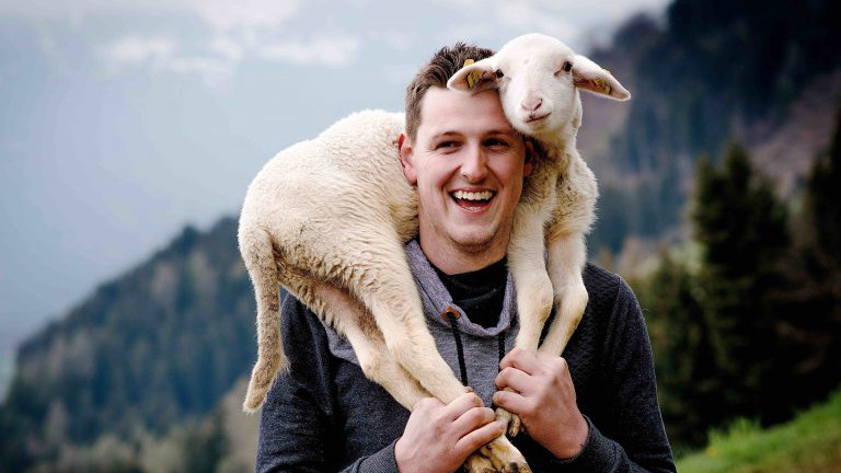 Matthias Kollnig mit einem Lamm auf seinen Schultern