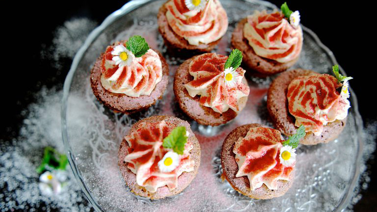 Cupcakes mit rotem Himbeerzucker und Gänseblümchen