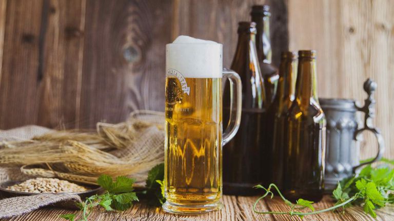 Bierglas und Flaschen auf Holztisch