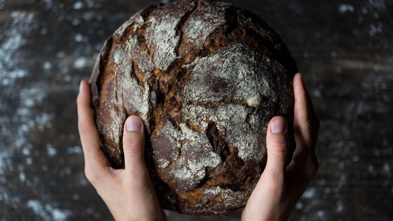 Hände halten einen Brotlaib