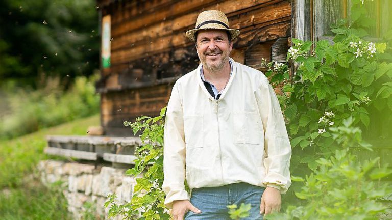 Mann vor einem Bienenhaus