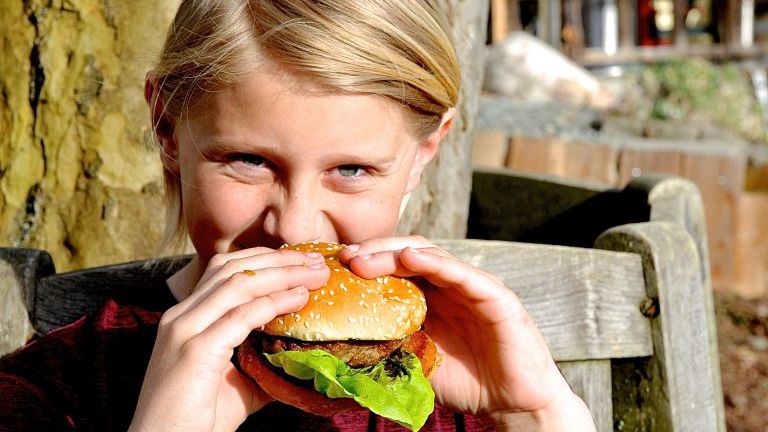 Bub beißt in einen Burger