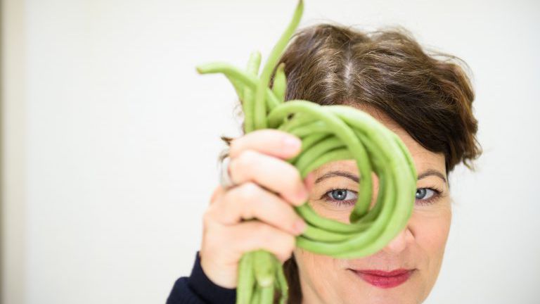 Frau schaut durch einen Ring aus Bohnen
