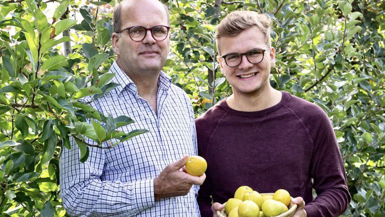 Mann mit Apfel in der Hand, junger Mann mit Apfelkorb