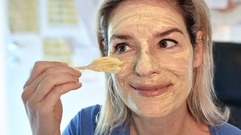 Frau trägt eine Gesichtsmaske auf