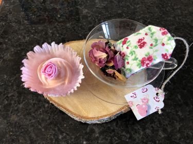 Glas Teetasse mit Rosenblüten gefüllt, Schranksäckchen in Teebeutel Form mit Lavendel und eine Rosenseife
Liebevoll verpackt auf Holzbrett oder Geschenkskarton 